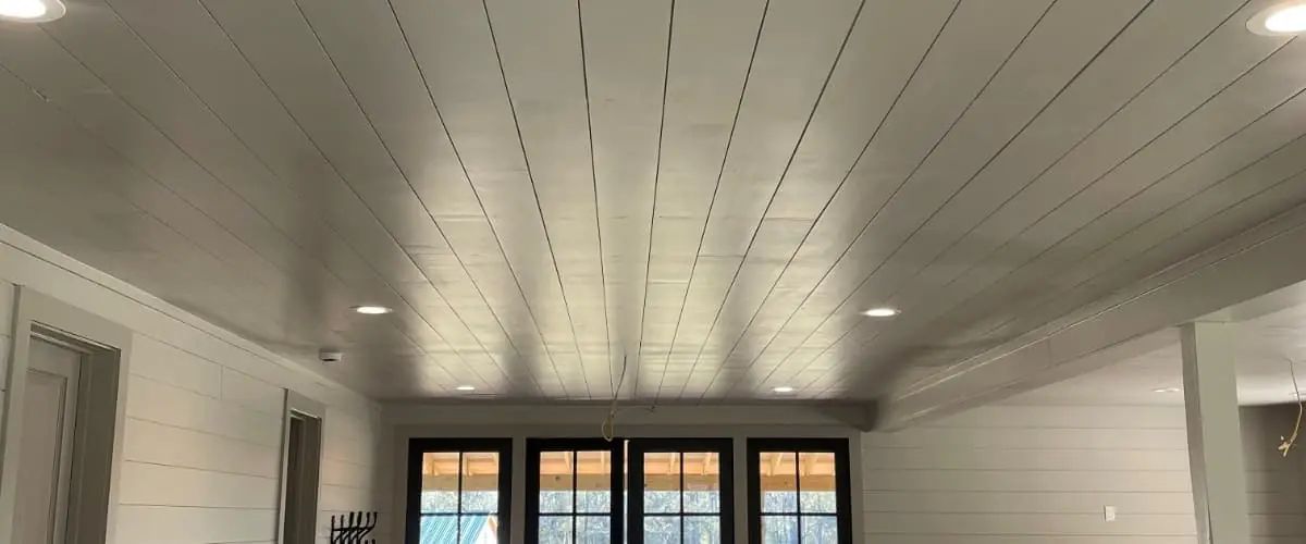 White shiplap walls in a bright open plan living room