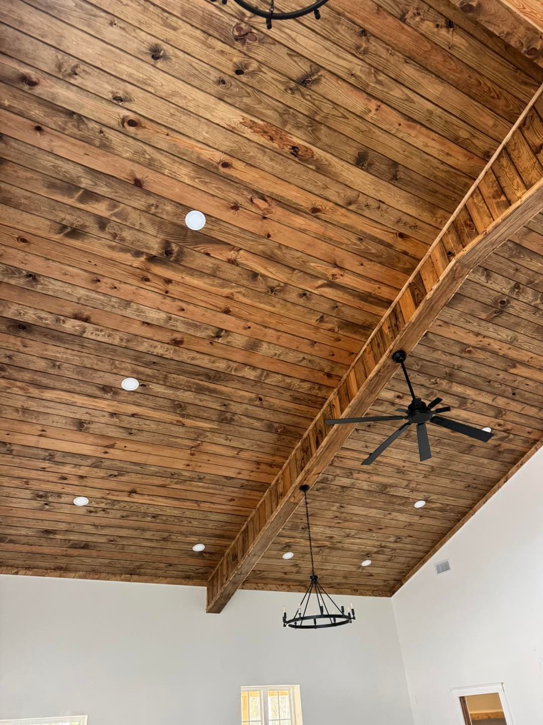 Stained pine tongue and groove ceiling in a residential great room