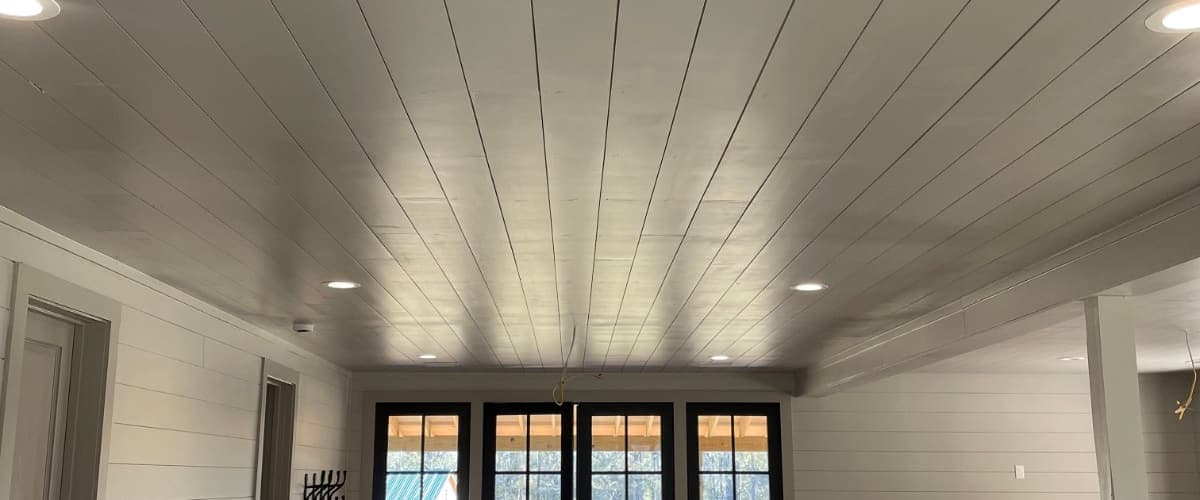 White shiplap walls in a bright open plan living room