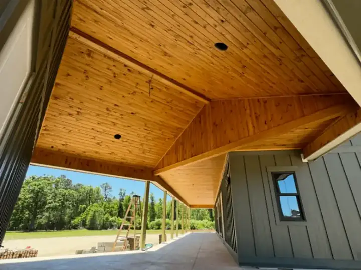 Covered porch ceiling finished in warm tongue and groove boards
