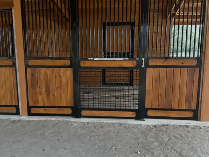 Horse stall front with wood infill panels and black steel framing